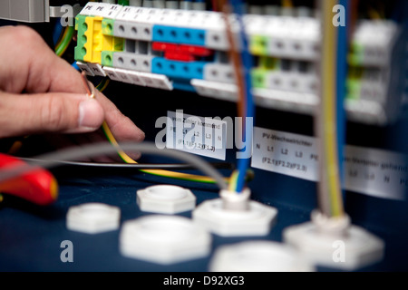 Un elettricista lavorando su una scatola di fusibili, close-up Foto Stock