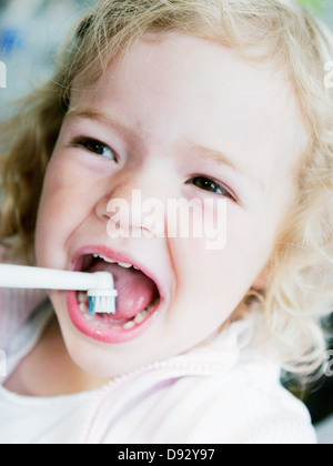 Felice ragazza spazzolatura dei denti Foto Stock