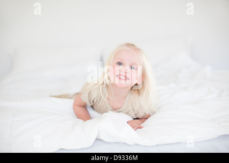 Bambina giacente sul letto Foto Stock