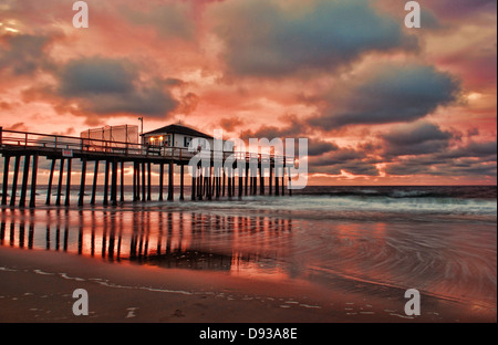 Sunrise in un cielo nuvoloso su un molo di pesca Foto Stock