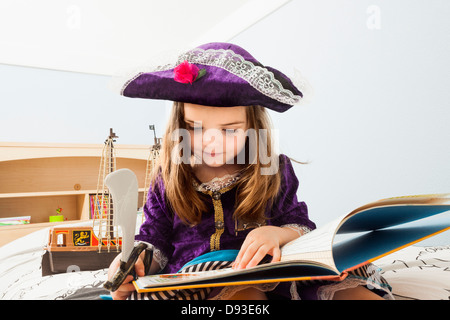 Ragazza caucasica la lettura di un libro sul letto Foto Stock