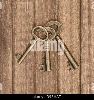 Tre vecchie chiavi su un sfondo di legno Foto Stock