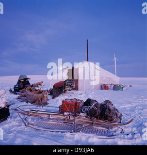 Casa ricoperta di neve con i bagagli su slitta Foto Stock