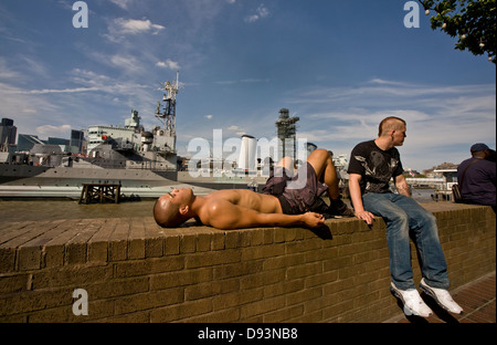 Due uomini in relax sulla parete del fiume, South Bank di Londra. Foto Stock