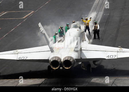 Una flotta di aeromobili guide direttore un F/A-18C Hornet fighter aircraft su una catapulta sul ponte di volo della portaerei USS Dwight D. Eisenhower Giugno 8, 2013 operanti nel Mare Arabico. Foto Stock