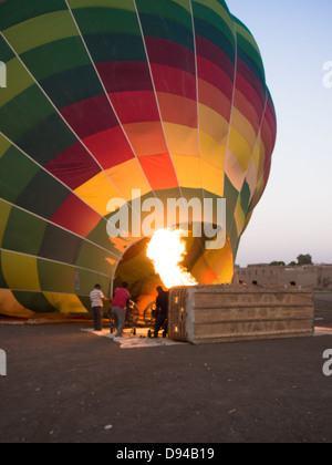 Una mongolfiera è riempito con aria calda dalla combustione di gas e ventilatori sulla riva occidentale del fiume Nilo a Luxor, Egitto Foto Stock