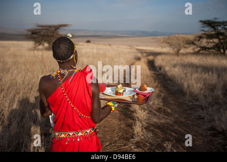 Maasai tribesman offrendo la colazione Foto Stock