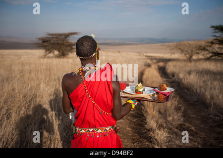 Maasai tribesman offrendo la colazione Foto Stock