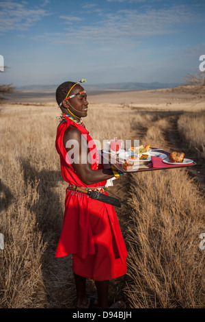 Maasai tribesman offrendo la colazione Foto Stock