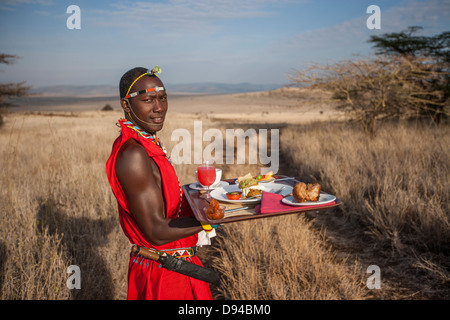 Maasai tribesman offrendo la colazione Foto Stock