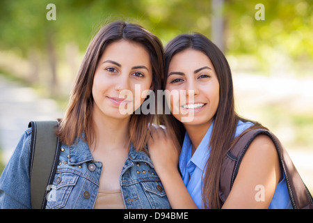 I giovani adulti razza mista Gemelle ritratto indossando zaini all'esterno. Foto Stock