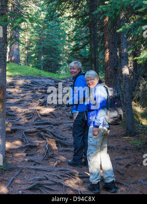 Due donne gli escursionisti a piedi attraverso la foresta, Jaspr National Park, Canada Foto Stock