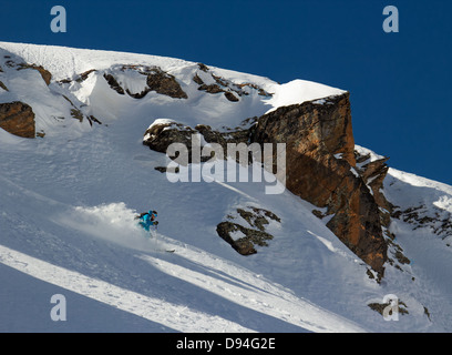 Donna sciatore nella neve profonda su un ripido pendio nella zona di ​​rocks Foto Stock