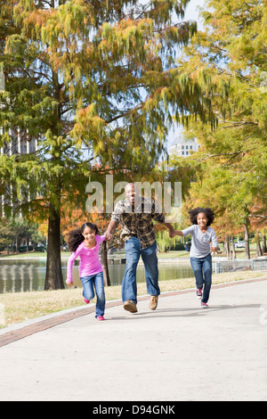 Padre e figlie giocare nel parco Foto Stock