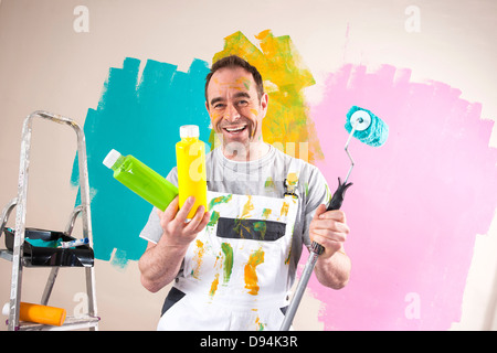 Uomo maturo rinnovando la sua casa e decidere tra i colori di vernice Foto Stock