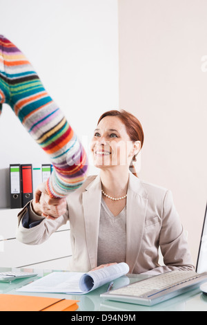 Imprenditrici stringono le mani in Office Foto Stock