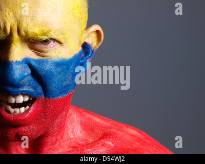 L'uomo faccia dipinta con bandiera colombiana. L'uomo è arrabbiato e composizione fotografica lascia solo metà della faccia. Foto Stock