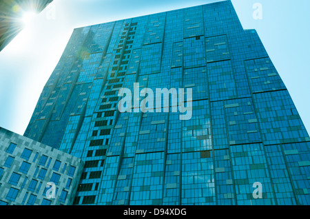 La prospettiva e la parte inferiore dell'angolo di vista sullo sfondo di un moderno edificio di vetro grattacieli oltre il cielo blu