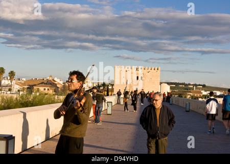 Il violino busker sul ponte romano (Puente Romano) al tramonto Cordoba Andalusia Andalusia Spagna Europa Foto Stock