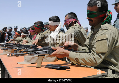 Afghan Polizia Locale reclute ufficiali dimostrano la loro conoscenza di AK-47 fucili a canna rigata con lo smontaggio e il montaggio della armi mentre gli occhi bendati durante un ALP Ceremonia di consegna dei diplomi a livello regionale ALP training center Giugno 6, 2013 in Lashkar Gah distretto, provincia di Helmand, Afghanistan. Foto Stock