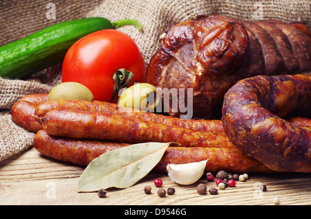 Salsiccia affumicata, la carne e le verdure sul tavolo di legno Foto Stock