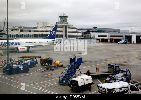 Guardando fuori attraverso la finestra del terminale al vecchio controllo originale edificio a torre e lo stile internazionale terminal presso l'aeroporto di Dublino te Foto Stock