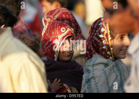 Rajasthani tribali donna con il tradizionale anello di naso in piedi in mezzo alla folla di uomini, Rajasthan, India Foto Stock