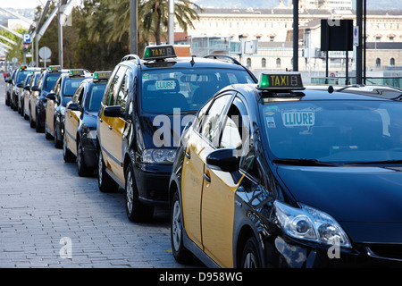 Fila di nero e giallo taxi a porto di Barcellona Catalonia Spagna Foto Stock
