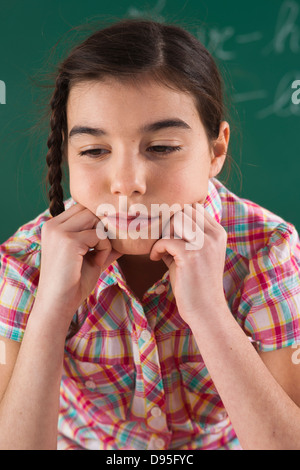 Close-up della ragazza appoggiata sulle mani in aula Foto Stock