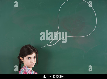 Ragazza di fronte di lavagna con bolla di parlato in aula Foto Stock