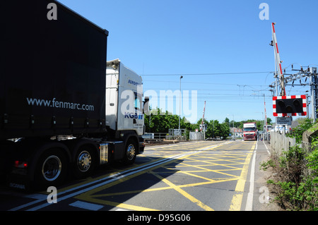 Le merci pesanti veicoli stradali al passaggio a livello ferroviario in Ely, Cambridgeshire, England, Regno Unito Foto Stock