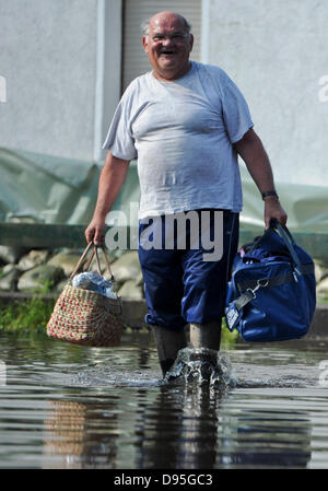 Wust, Germania. 12 Giugno, 2013. Un uomo cammina attraverso le inondazioni nella parte anteriore della sua casa con i bagagli in Wust, Germania, 12 giugno 2013. La maggior parte dei residenti di lasciare il villaggio allagata. Molte città lungo il fiume Elba sono state colpite dalle inondazioni. Foto: OLE SPATA/dpa/Alamy Live News Foto Stock