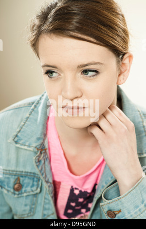 Testa e spalle Ritratto di ragazza adolescente appoggiata sul gomito, in Studio Foto Stock