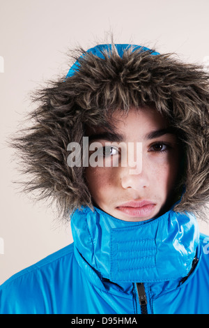 Ritratto di ragazzo in giacca invernale con pelliccia rifilati cofano in Studio Foto Stock