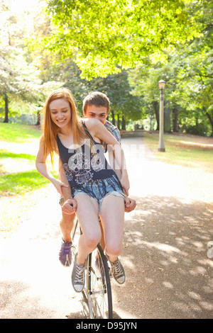 Coppia giovane riding bike insieme in un parco in una calda giornata estiva a Portland, Oregon, Stati Uniti d'America Foto Stock
