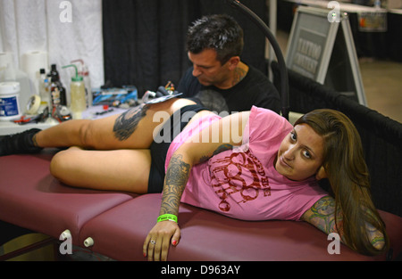 Signora giovane ottenendo un tatuaggio al New York Tattoo Festival in Uniondale, Long Island, New York Foto Stock