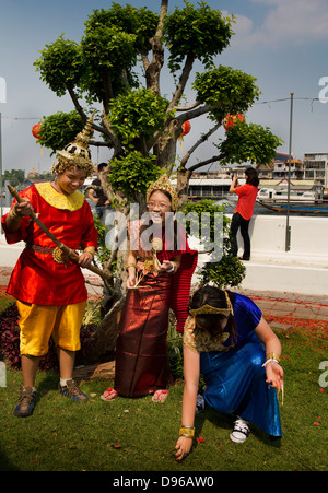 I turisti essendo vestito in tradizionali abiti tailandesi e in posa per le fotografie nella motivazione di Wat Arun, un tempio buddista Foto Stock