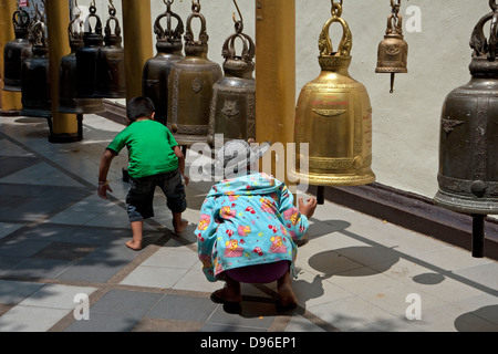 Due bambini anello campane al Wat Phra That Doi Suthep vicino a Chiang Mai, Thailandia Foto Stock