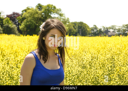 Posizione modello di sparare i campi di colza donna giovane adolescente sole estivo Foto Stock