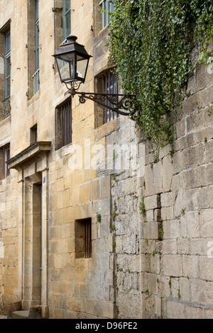 Ferro battuto lampione sporgente dal medievale edifici di pietra arenaria di affascinante Sarlat Dordogne regione della Francia Foto Stock