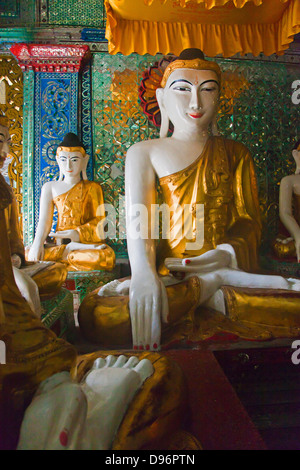 Statue di Buddha sono venerate presso la Shwedagon Paya o pagoda che risale al 1485 - YANGON, MYANMAR Foto Stock