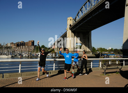 Entusiasta per chi ama fare jogging lungo le False Creek seawall passerella con il Burrard Street bridge sopra Vancouver British Columbia Foto Stock