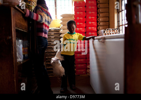 Una giovane ragazza africana indossando South African football shirt detiene il pollo in locali super mercato Bochum nel distretto del Limpopo Foto Stock