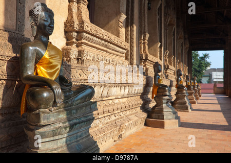 Chiudere orizzontale di statue del Buddha fodera veranda al Wat Ho Phra Keo o il Tempio del Buddha di smeraldo in Vientia Foto Stock