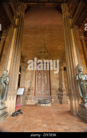 Vista verticale del buddha statue che ornano l'ingresso al Wat Ho Phra Keo o il Tempio del Buddha di Smeraldo di Vientiane. Foto Stock