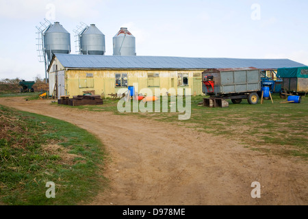 Per essere legendées dopo la modifica di tre alimentazione del metallo sili di stoccaggio e da un fienile in cortile, a Alderton, Suffolk, Inghilterra Foto Stock