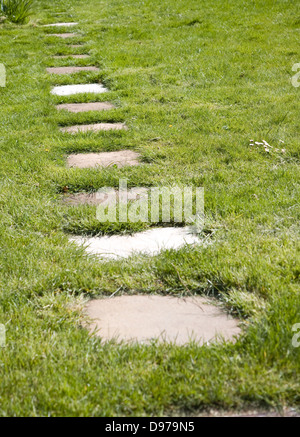 Trampolino pavimentazione in lastre formano un percorso attraverso prato in un giardino, REGNO UNITO Foto Stock