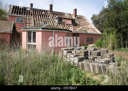 Casa essendo demolito, Shottisham, Suffolk, Inghilterra tetto in amianto piastrelle impilate per la rimozione in sicurezza. Foto Stock