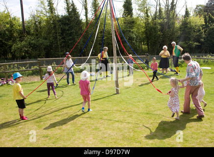 Bambini danza attorno un maypole in un paese di lingua inglese festival, Shottisham, Suffolk, Inghilterra Foto Stock