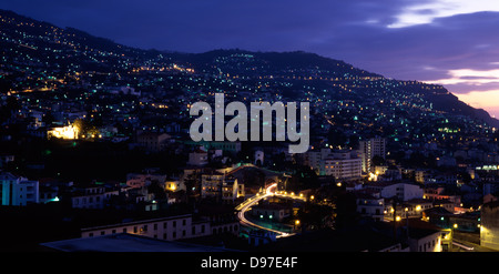 Una collina di proprietà a crepuscolo, con luci da proprietà e le luci di strada, pronto per la notte nella città di Funchal, Madeira Island, l'Europa. Foto Stock